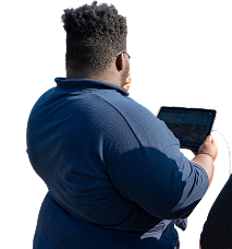 Person using tablet outdoors, seen from behind.