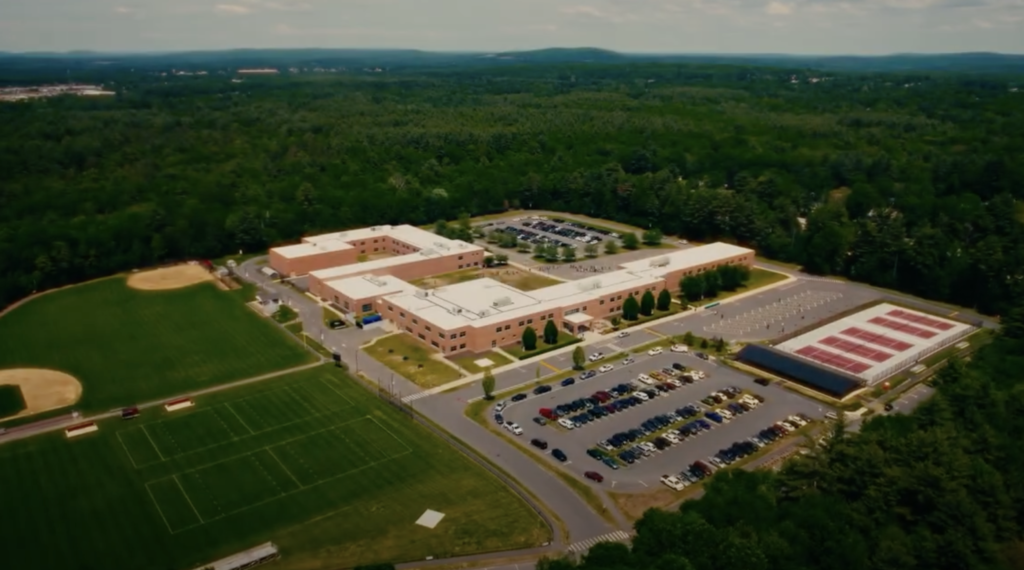 Aerial view of school with parking lot and fields.