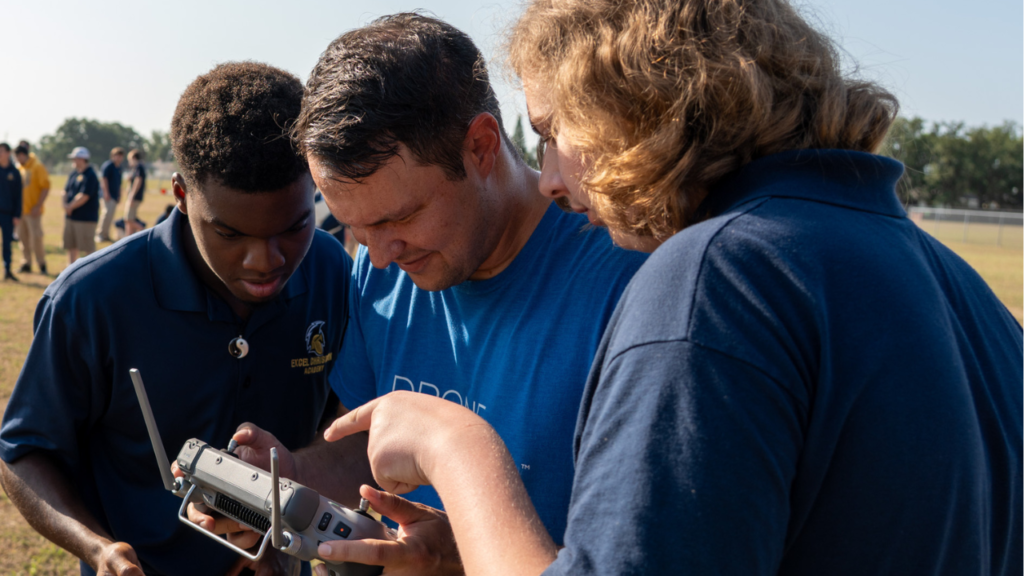 Group learning to operate a drone controller outdoors.