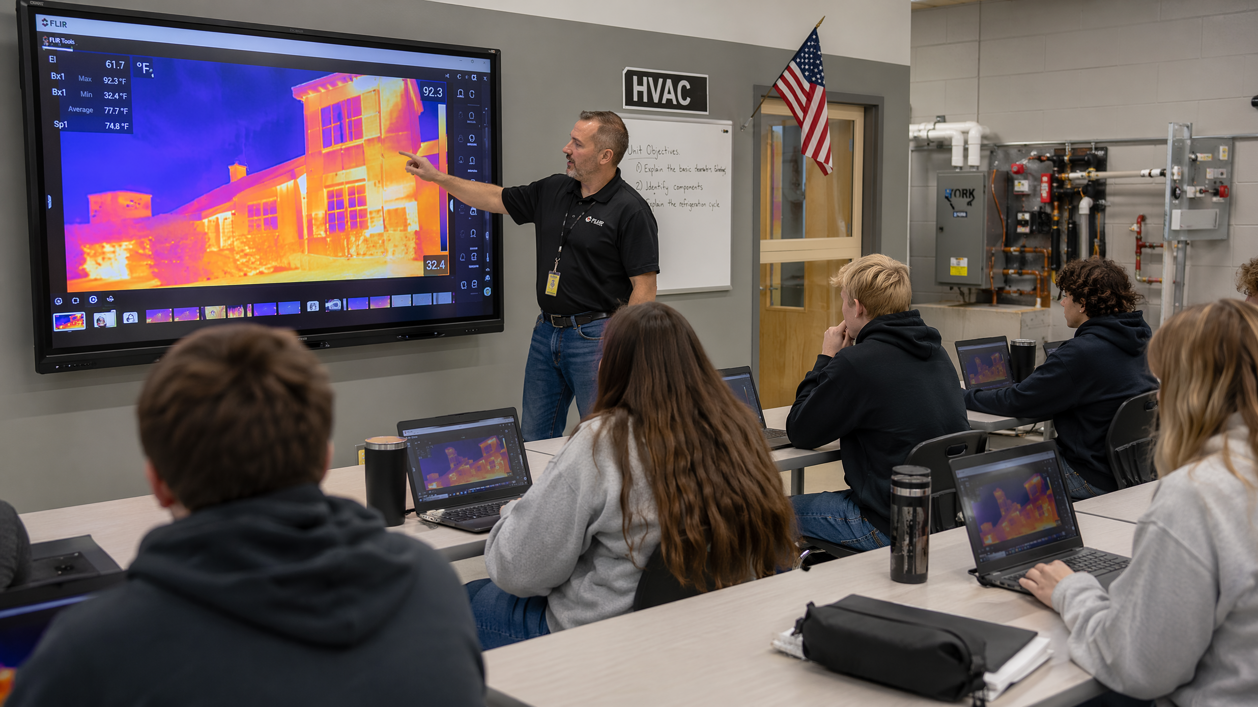 CTE teacher explaining thermal imaging data on a smart board to engaged high school students